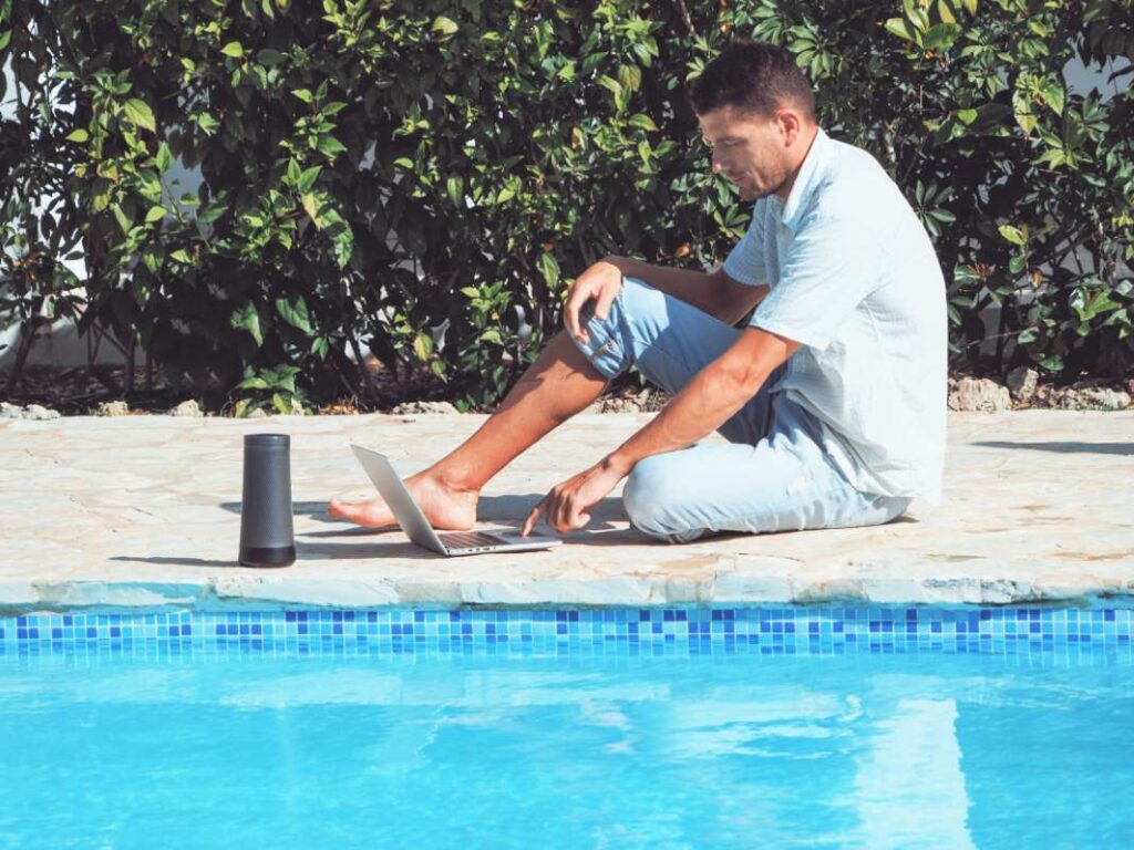 Pool route owner working on laptop by a swimming pool